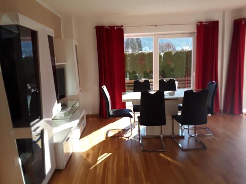 a dining room with a table and chairs and a large window at Apartments Steger in Faak am See