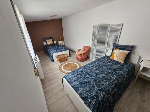 a small bedroom with two beds and a window at Gîte de la Tour d'horloge in Carvin
