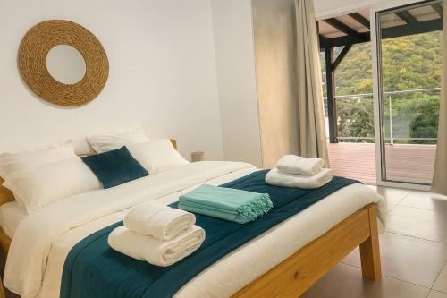 a bedroom with a bed with towels on it at Villa 4 étoiles Le Pic de Malendure in Bouillante