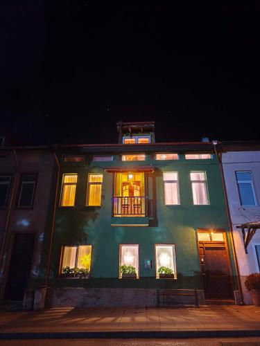 a green building with lit up windows at night at PORTALA Urban Lodge in Rila