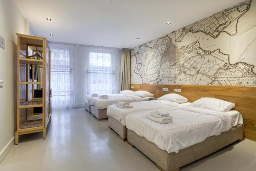 a bedroom with three beds and a wall mural at Marnix360apartments-Suites Jordaan in Amsterdam