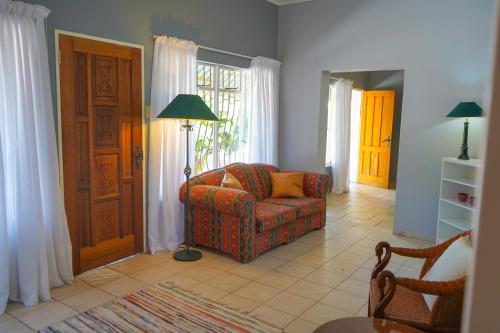 a living room with a chair and a floor lamp at Okajo Safari Lodge in Wilhelmstal