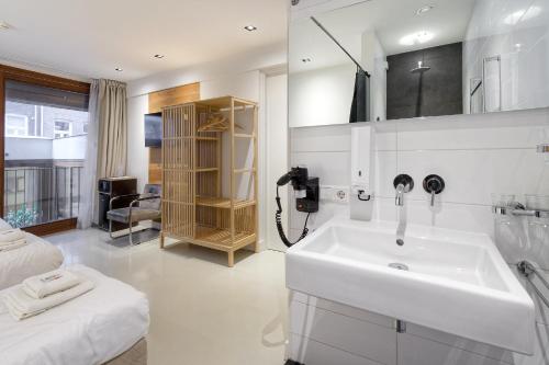 a white bathroom with a sink and a bed at Marnix360apartments-Suites Jordaan in Amsterdam