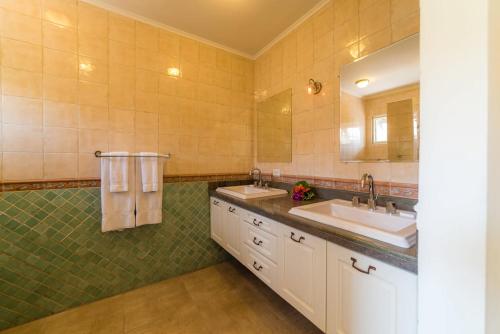 a bathroom with two sinks and a large mirror at Villa Kas ku Playa 55 - Coral Estate in Willibrordus