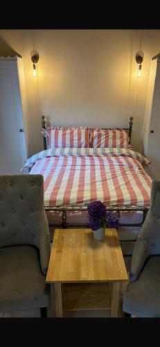 a bedroom with a bed and a coffee table with a bed at Half Pint Cottage in Draperstown
