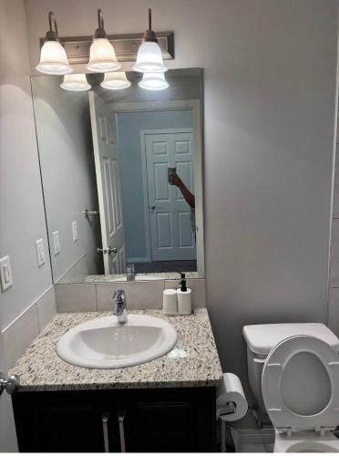 a bathroom with a sink and a toilet and a mirror at Quiet Comfortable 1-Bedroom in Calgary