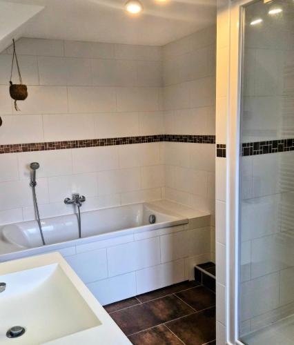 ein weißes Badezimmer mit Badewanne und Dusche in der Unterkunft La Petite Maison de Vernon-Giverny, gîte cosy avec jardin à 7 min de Giverny, Sauna, Wifi, parking gratuit dans la rue, calme in Vernon