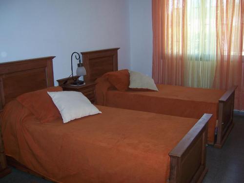 1 dormitorio con 2 camas, lámpara y ventana en El Descanso en 