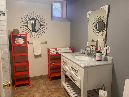 a bathroom with a sink and a mirror at The Jellybean Heritage Inn in St. John's