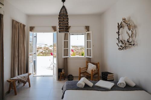 a bedroom with a bed and a large window at Nissos Suites in Apollonia