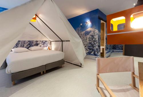 a bedroom with a tent with a bed and a chair at Hotel Base Camp Lodge - Bourg Saint Maurice in Bourg-Saint-Maurice