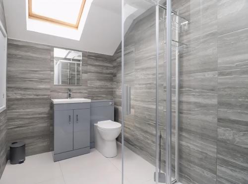 a bathroom with a toilet and a glass shower at The View - Peaceful Duplex Apartment with Views, Parking & Wifi in Nuneaton