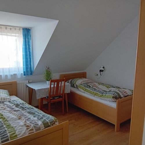 a room with two beds and a table and a table and chairs at Ferienwohnung Dietz in Dießen am Ammersee