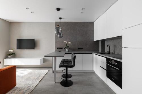 una cucina con mobili bianchi e un tavolo nero di Modern combo - Chisinau a Chişinău