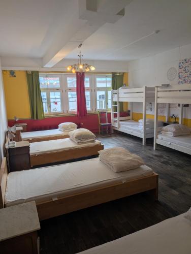 a bedroom with three bunk beds and a chandelier at Black Forest Hostel in Freiburg im Breisgau