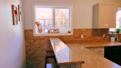 a kitchen with a counter top and a window at Yuan's Cozy 4BR House in Charlottetown in Cornwall