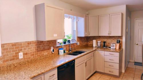 a kitchen with white cabinets and a sink at Yuan's Cozy 4BR House in Charlottetown in Cornwall