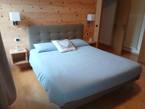 a large bed with a pillow on it in a bedroom at Casa Micéi in Tesero