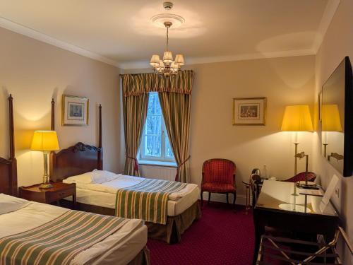 a hotel room with two beds and a window at Dwór Sieraków in Sieraków