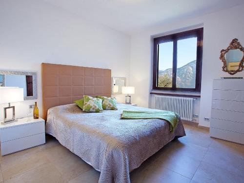 a bedroom with a bed and a mirror and a window at Apartment Bella Vista In Mezzegra in Mezzegra