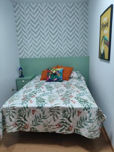a bedroom with a bed with a comforter on it at Mirador de los pollitos in Sotillo de la Adrada