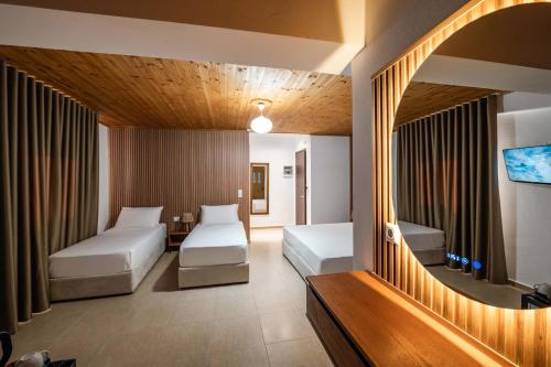 a hotel room with two beds and a tv at ABEDINI Boutique Hotel Ksamil in Ksamil
