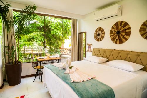 a bedroom with a bed and a large window at Villa Botanic Garden in Itacaré