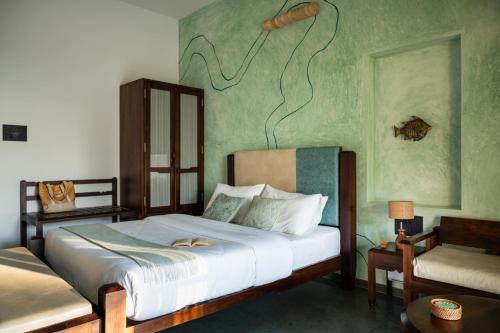 a bedroom with a bed with a painting on the wall at illa - By the sea in Udupi