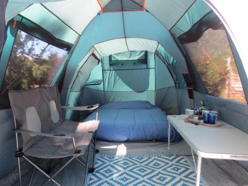 a tent with a bed and a table in it at Glamping Mañihueico in Contao
