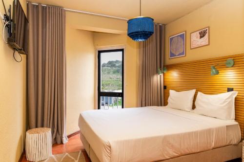 a bedroom with a large bed and a window at WOT Ocean Soul in Sintra