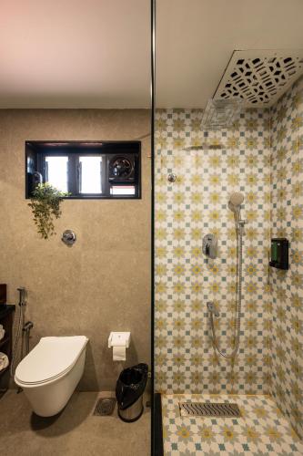 a bathroom with a shower with a toilet and a sink at illa - By the sea in Udupi