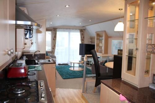 a kitchen and living room with a stove top oven at Golden sands ingoldmells plot 337 in Skegness