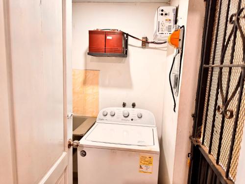 a small kitchen with a stove and a microwave at 1Dom Rep - Huge cozy 3 bedrooms - close to all transportation Jacobo Majluta - Residencial Paradise V Colina Arroyo 1 in Santo Domingo