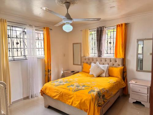 a bedroom with a bed with yellow sheets and windows at 1Dom Rep - Huge cozy 3 bedrooms - close to all transportation Jacobo Majluta - Residencial Paradise V Colina Arroyo 1 in Santo Domingo