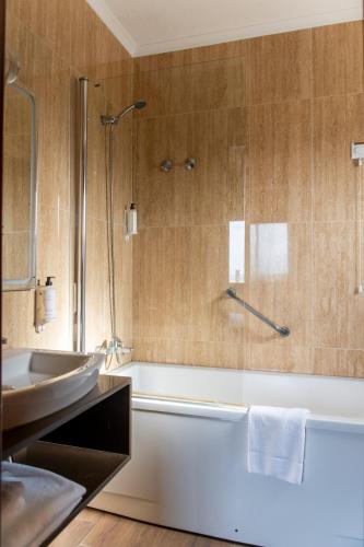 a bathroom with a tub and a sink and a shower at WOT Ocean Soul in Sintra