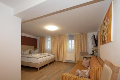 a hotel room with a bed and a couch at Hotel Maximilian in Zeitz
