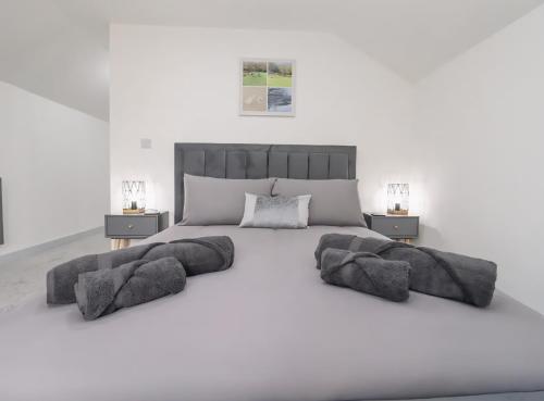 a white bedroom with a large bed with pillows at The View - Peaceful Duplex Apartment with Views, Parking & Wifi in Nuneaton