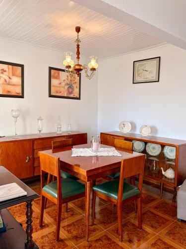 a dining room with a wooden table and chairs at Vista do Pilar in Conceição