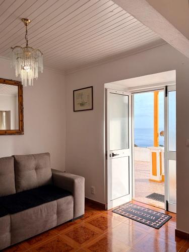 a living room with a couch and a view of the ocean at Vista do Pilar in Conceição