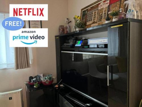 a black entertainment center with a television in a living room at ただいま!と帰りたくなる場所 Naotoko Minpaku #HG1 首都高入口迄5分 広々94平米 一戸建て貸切 高速Wi-Fi 無料駐車場付 in Tokyo