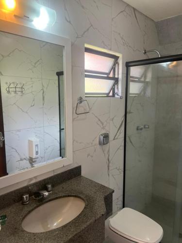 a bathroom with a toilet and a sink and a shower at Tureck Garten Hotel in Corupá