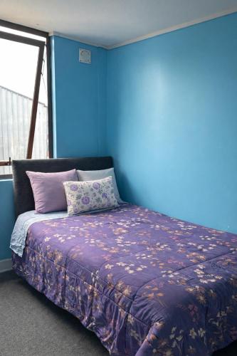 a bedroom with a bed with a blue wall at Jacinta in Puerto Montt