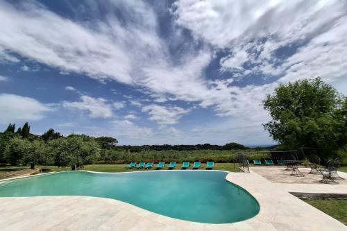 a swimming pool with chairs and a cloudy sky at Villa Montepulciano by Mmega in Montepulciano