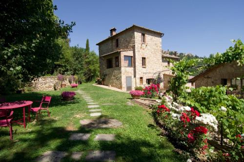 a stone house with a table and chairs in a yard at Villa Montepulciano by Mmega in Montepulciano