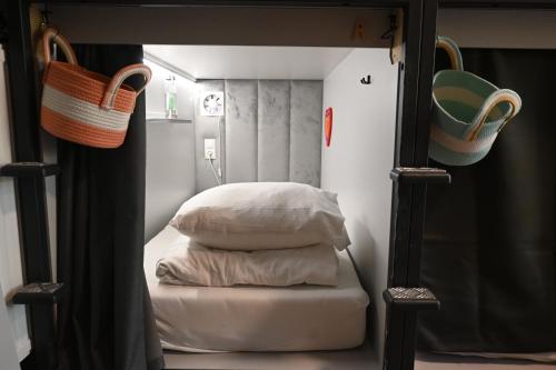 a bedroom with a bed with pillows and a mirror at Dutchies Hostel in Amsterdam