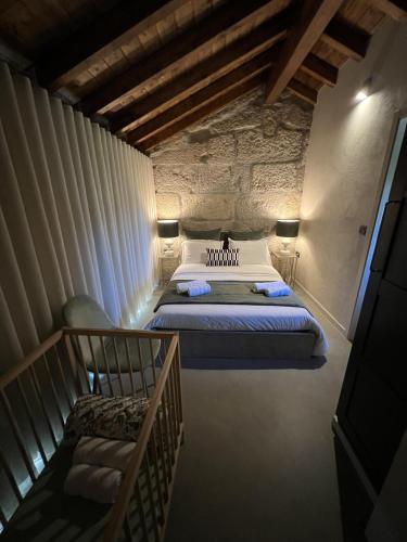 a bedroom with a large bed and a staircase at Casa da eira in Santo Emilião