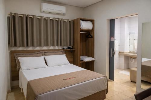 a small bedroom with a bed and a bathroom at Revitalle Hotel in Votuporanga