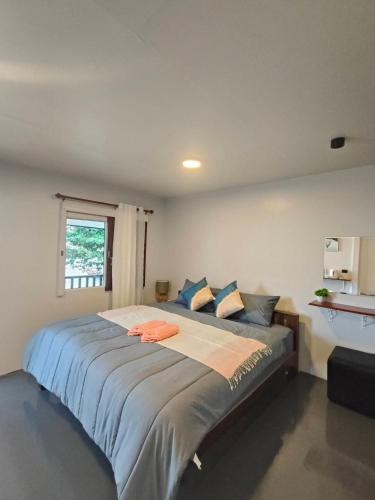 a bedroom with a large bed with blue pillows at Libong haven in Ko Kwang