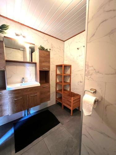 a bathroom with a sink and a mirror at Veluwe Park Reewold Chalet Infinity in Putten