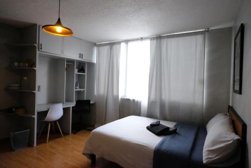 a bedroom with a bed and a window and a desk at Compact Studio Apartment Casa Icacos Apt 6 in Mexico City